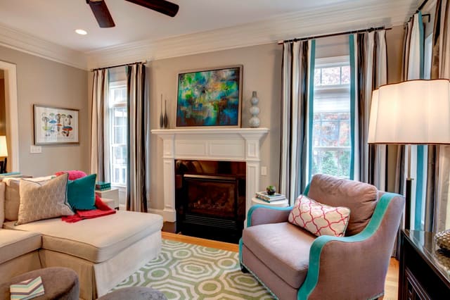 Colorful Family Room with striped drapery panels and artwork over fireplace