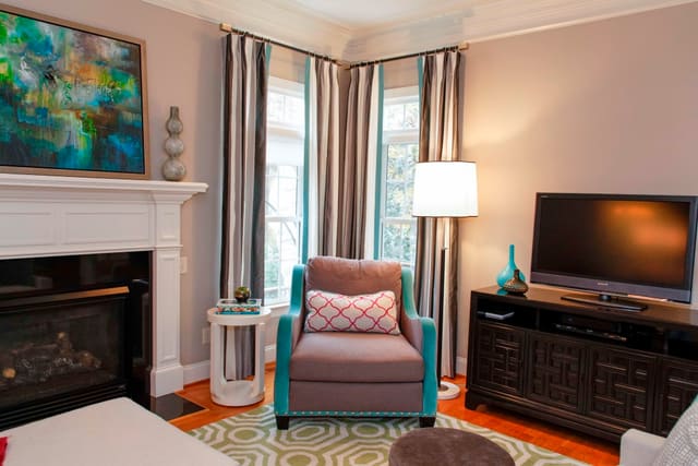 Colorful Family Room with striped drapery panels and artwork over fireplace