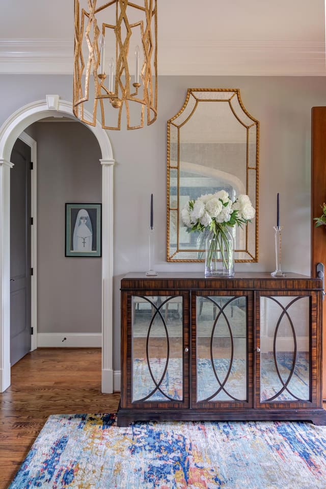 Lillian August sideboard in the entryway underneath a beautiful Visual Comfort chandelier.