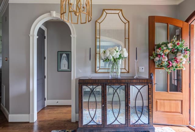 Lillian August sideboard in the entryway underneath a beautiful Visual Comfort chandelier.