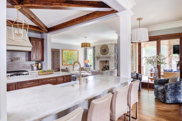 Open concept kitchen with two marble islands looking into the sitting room.