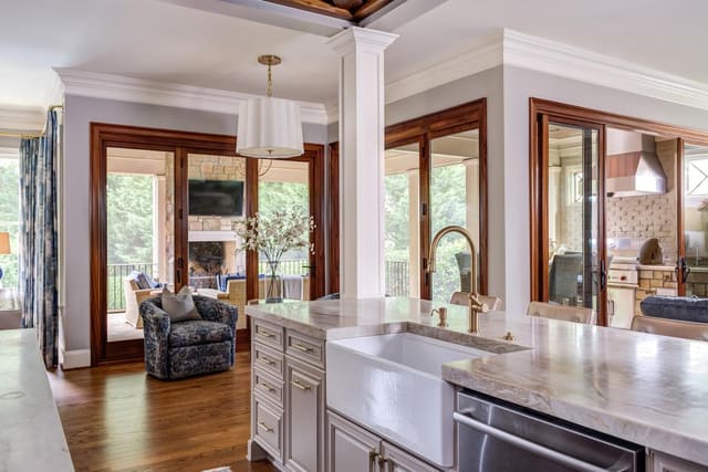 Open concept kitchen looking into the light and airy screened in back porch.
