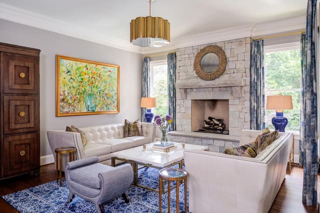 Two white leather tufted sofas in the sitting room split between a marble cocktail table.