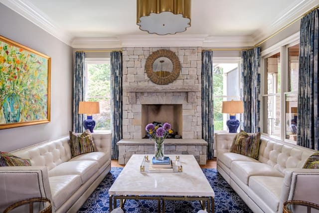 Two white leather tufted sofas in the sitting room split between a marble cocktail table.