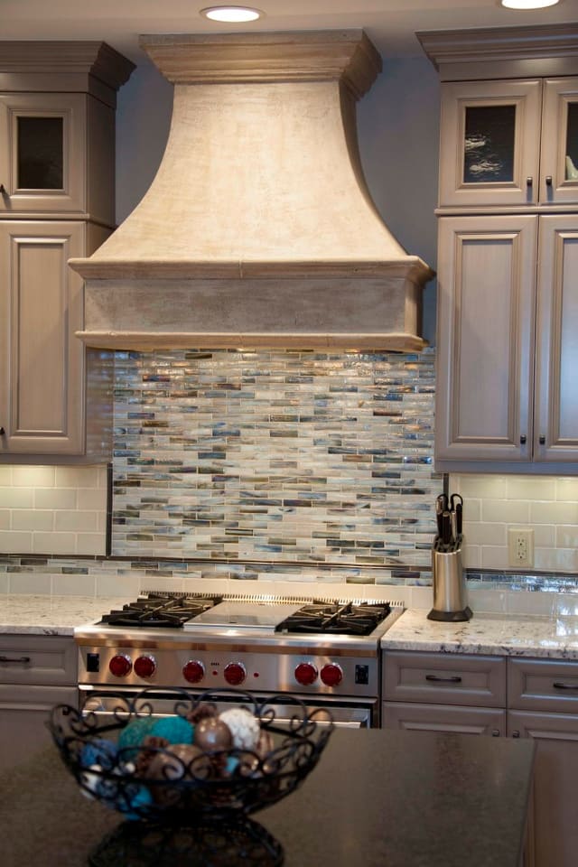 Remodeled Kitchen with tile backsplash, taupe cabinets, and custom stove range hood