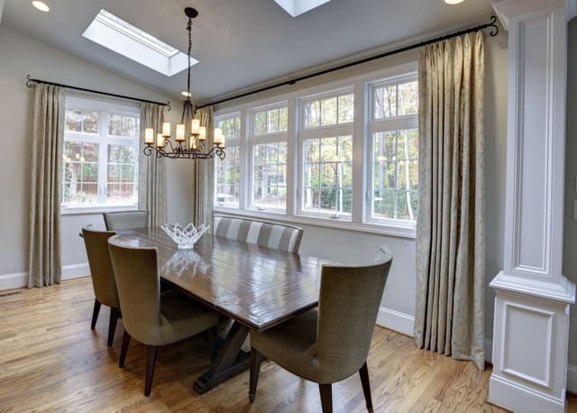 Breakfast Nook with mixed chair and bench seating and custom window treatments
