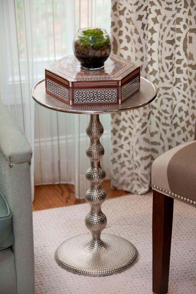 Closeup of hammered metal side table and beautiful window treatments
