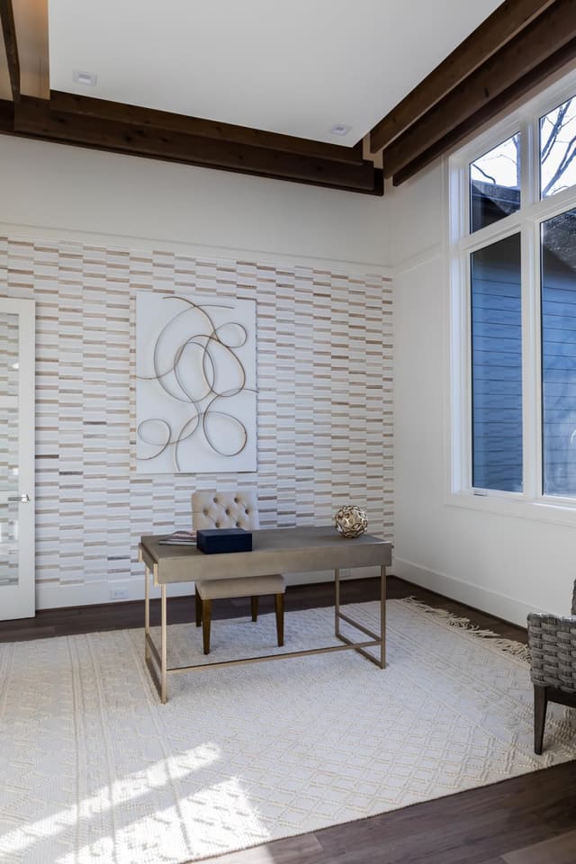 Study of Apex home with wall decor, floating desk and and cream chunky area rug.