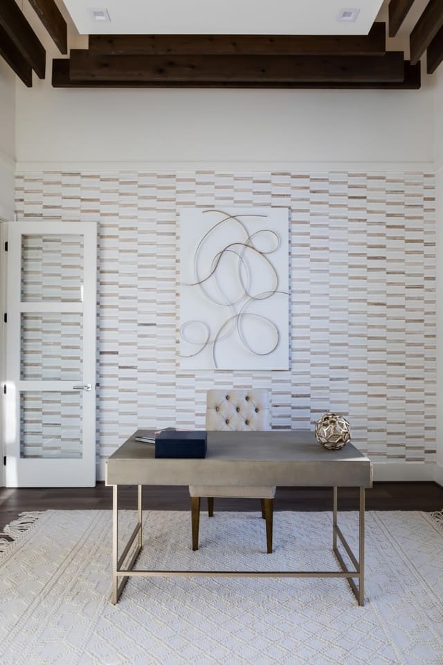 Study of Apex home with wall decor, floating desk and and cream chunky area rug.