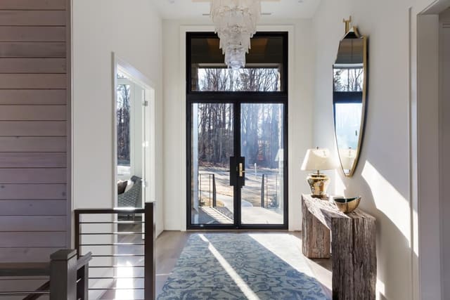Foyer of Apex home with glass doors and clear chandelier