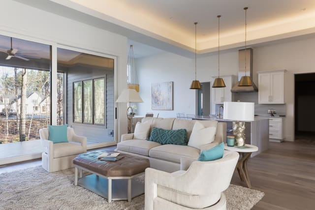 Family Room of Apex Home with sofa, swivel chairs and upholstered leather ottoman