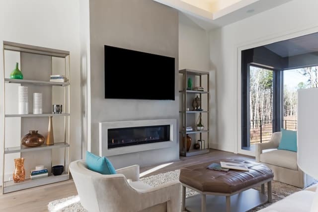 Family Room of Apex Home featuring linear fireplace with flanking etageres.