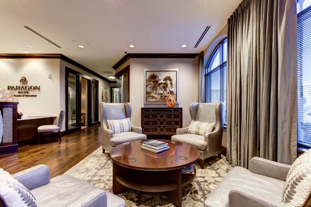 Reception area of Cary Bank with leather chairs flanking chest with silver striping.