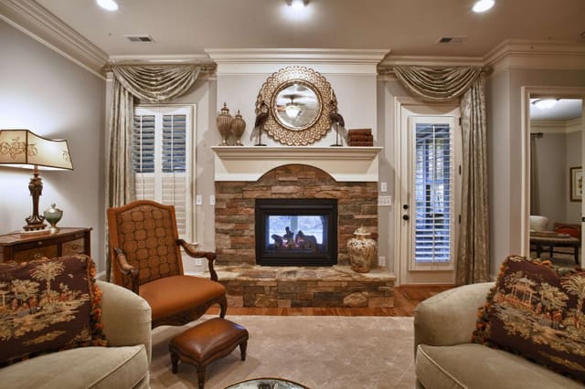 Elegant Living Room with mirror over two-way fireplace and custom window treatments