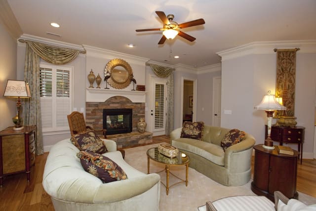 Elegant Living Room with mirror over two-way fireplace and custom window treatments