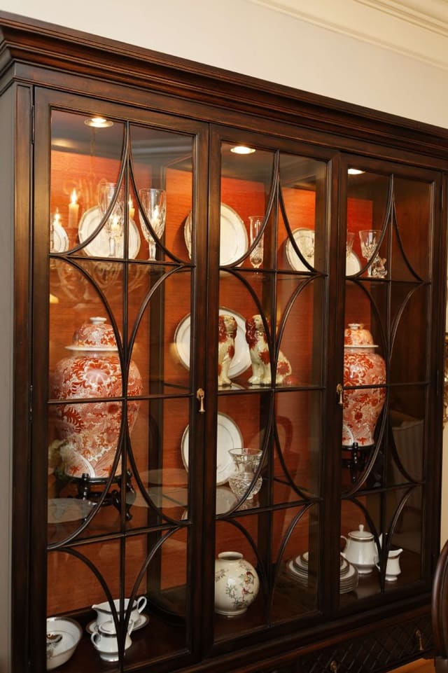 Hickory White china cabinet with coral fabric installed on back panels, and porcelain accessories