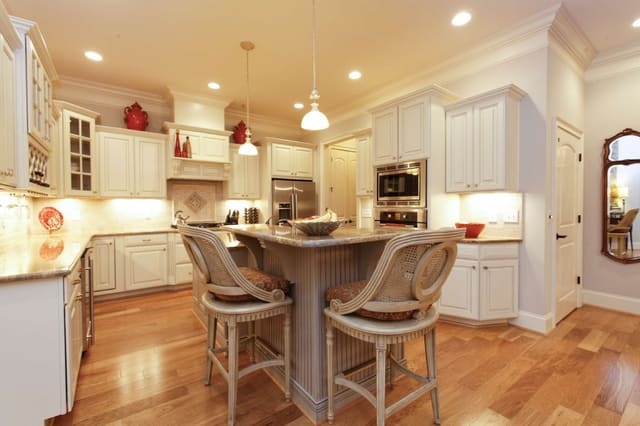 Kitchen with cream cabinets and Century barstools