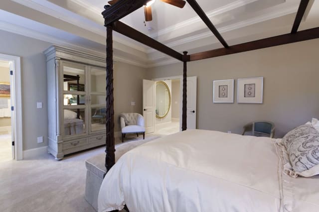 Master Bedroom with dark wood bed and mirrored armoire