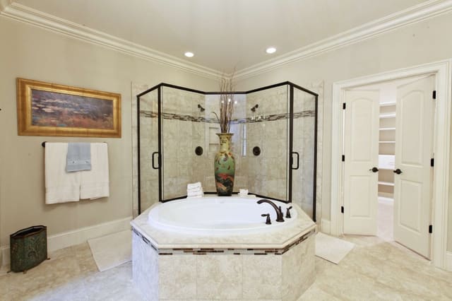 Master Bathroom featuring large colorful vase on tub ledge