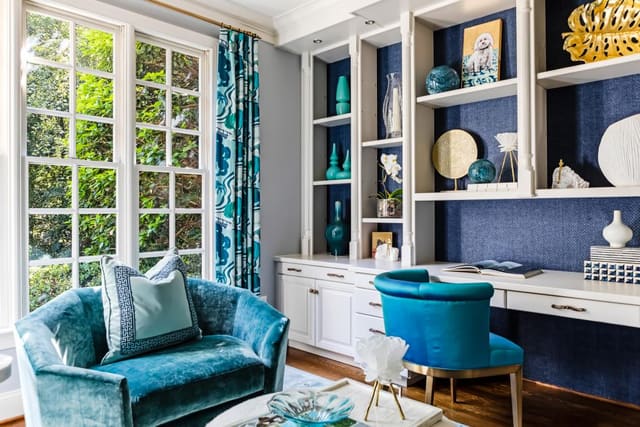 Study with wallpaper backed bookcases, turquoise furniture, and linen print drapery on gold hardware