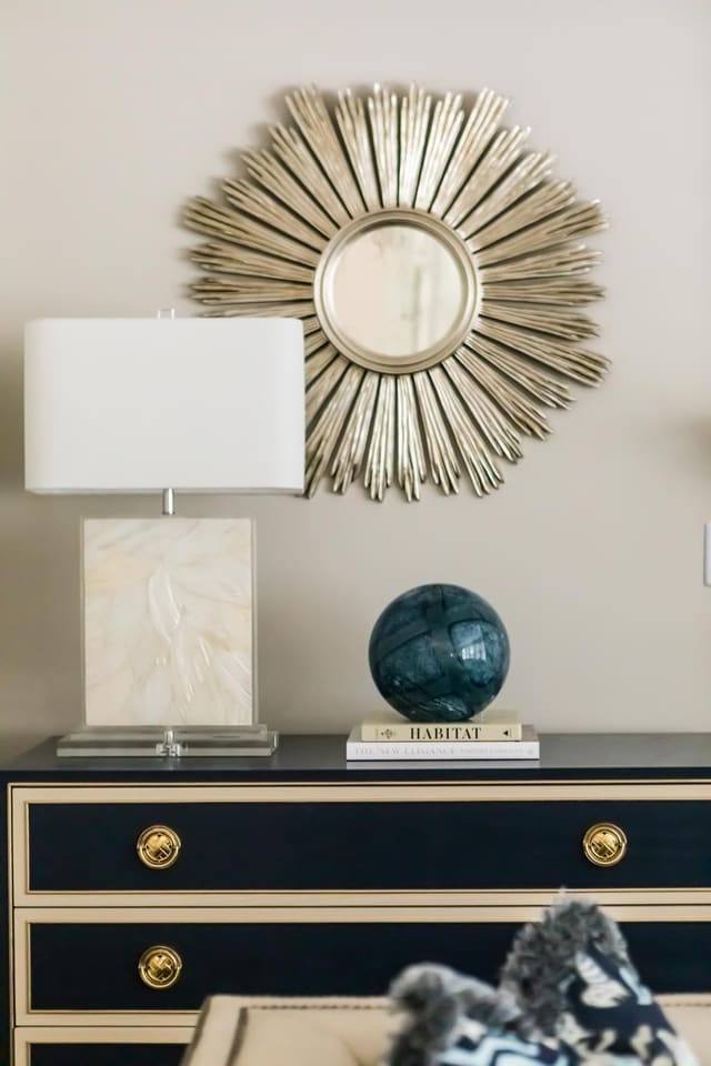 Close up of navy chest with mother of pearl lamp and antique silver mirror