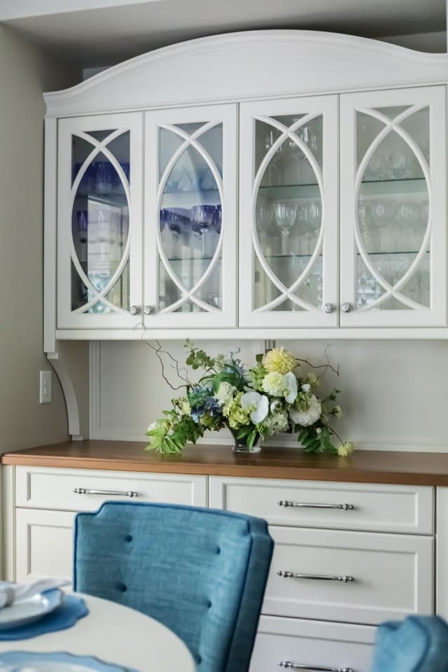 Close up of Wine Bar with white drawered cabinet base and glass front upper cabinets