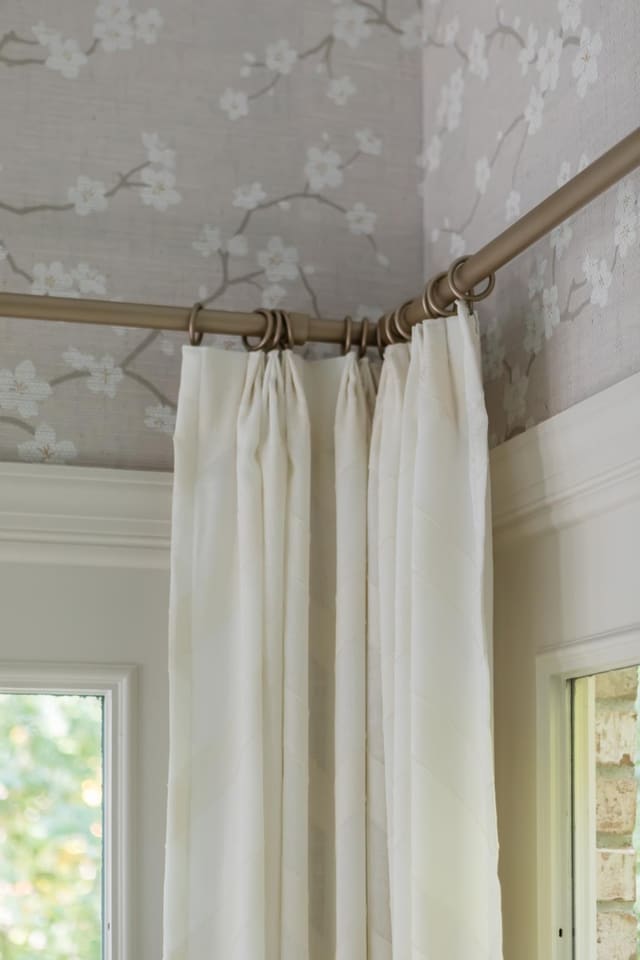 Close up of Dining Room window treatments in white chevron fabric on gold hardware.
