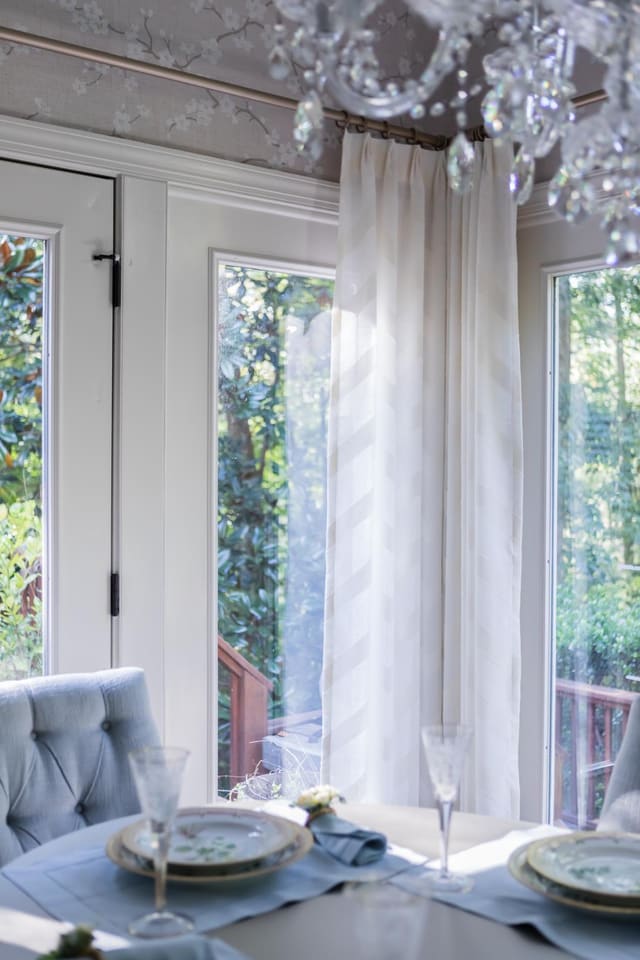 Close up of Dining Room window treatments in white chevron fabric on gold hardware.