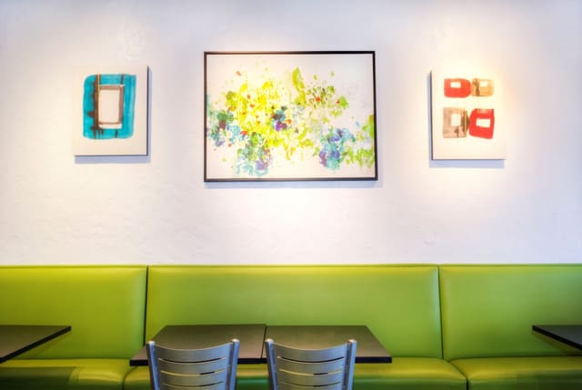 Interior of Diced Restaurant in Cary with Colorful Artwork, Green Laminate Banquettes, Black Tables, and Silver Chairs