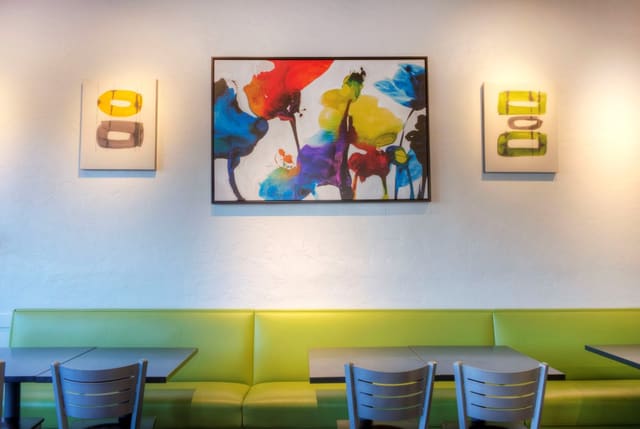 Interior of Diced Restaurant in Cary with Colorful Artwork, Green Laminate Banquettes, Black Tables, and Silver Chairs