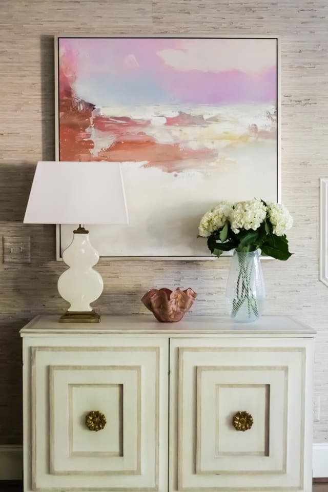 The soft grasscloth wallpaper provides the perfect backdrop for elegant details.