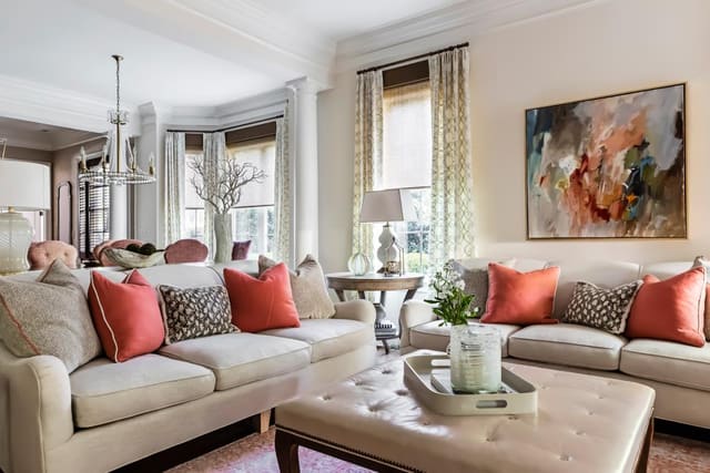 Close-up of twin sofas in Family Room in neutral fabric with coral pillows.