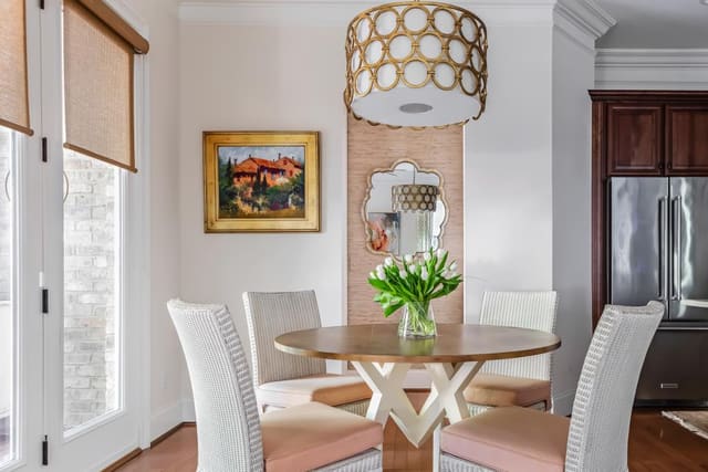 Breakfast Nook featuring two-toned table, wicker chairs and gold light fixture