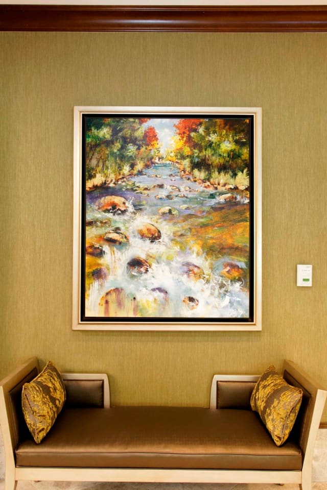 Bench with contrast pillows and original artwork at Paragon Bank