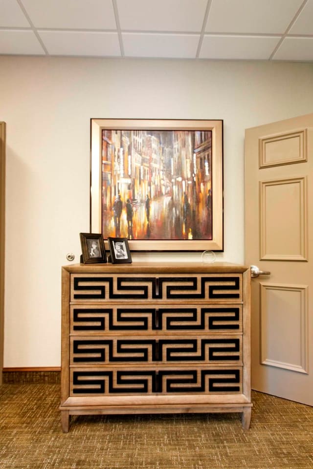 Greek key chest in contrasting finishes underneath giclee artwork