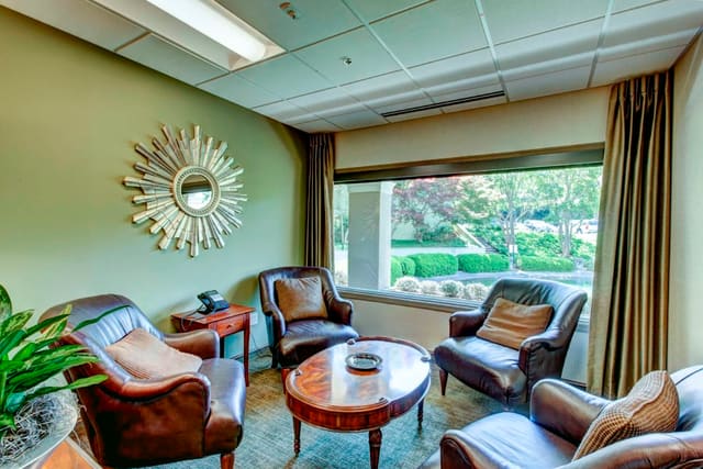 Seating area at Paragon Bank with custom drapery panels and sunburst mirror