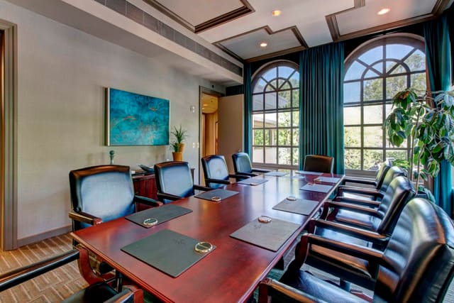 Custom drapery panels on arched windows, with original artwork, and beautiful ceiling details in Second Floor Conference Room at Paragon Bank