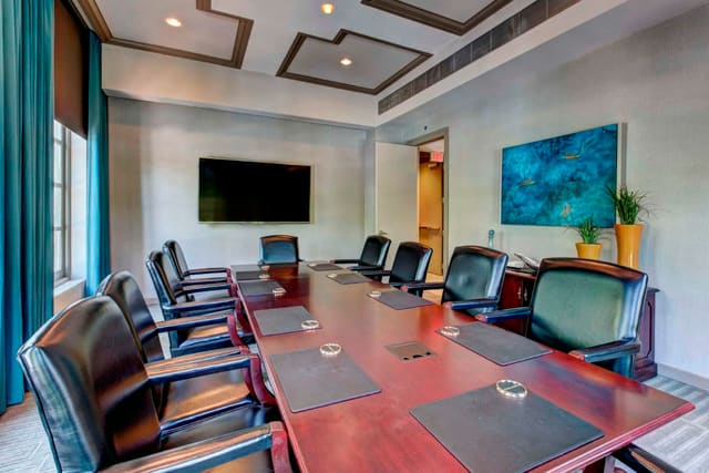 Custom drapery panels on arched windows, with original artwork, and beautiful ceiling details in Second Floor Conference Room at Paragon Bank
