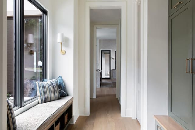 Transitional hallway with warm wood floors and built-in window seat