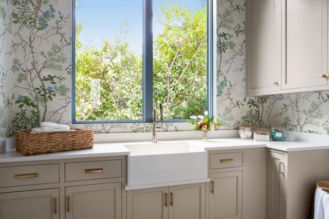 Laundry room with farmhouse sink and floral wallpaper