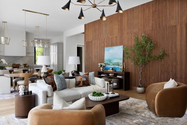 Open concept living room with accent wood-panelled wall and Black Chandelier