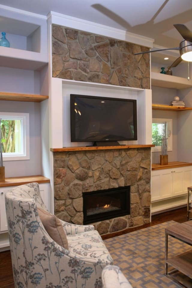 Family Room in Downtown Raleigh home with built in shelves around window and stone surrounding fireplace
