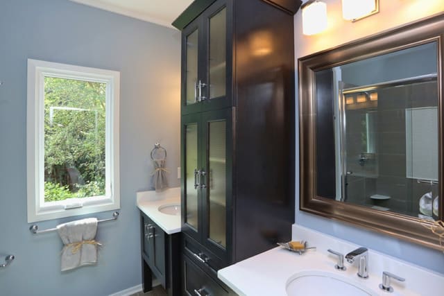 Bathroom in Downtown Raleigh home with black cabinet in between sinks