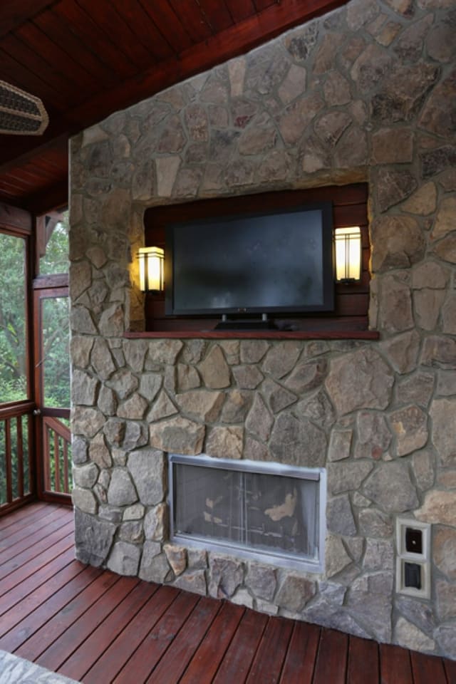 Screened porch in downtown Raleigh home with outdoor fireplace and wall mounted TV