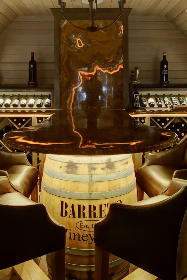 Wine Room with custom wine barrel base and backlit onyx top