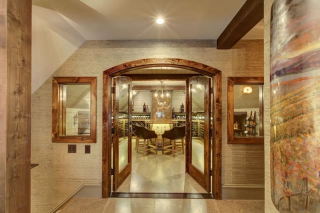 Entrance to Wine Room with view of grasscloth wallpaper surrounding door.