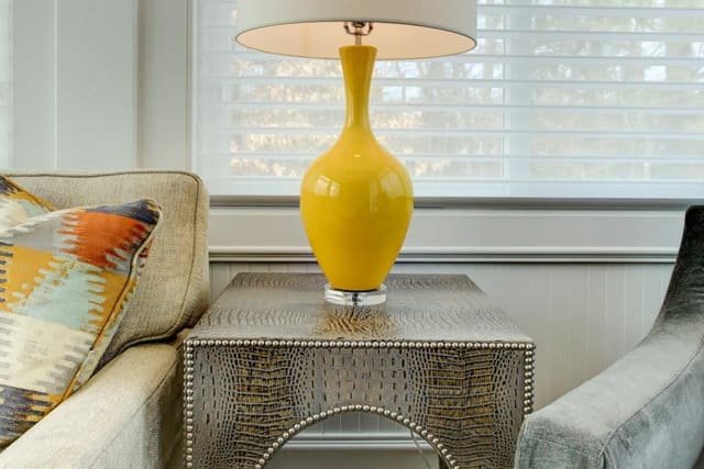 Close up of yellow/acrylic lamp on leather snakeskin table