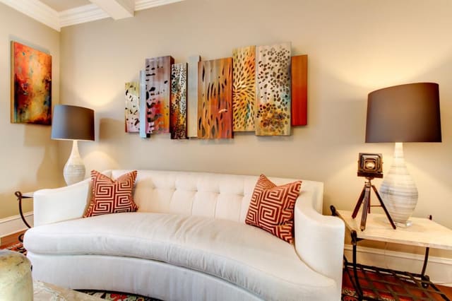 Living Room with curved white sofa and original metal artwork