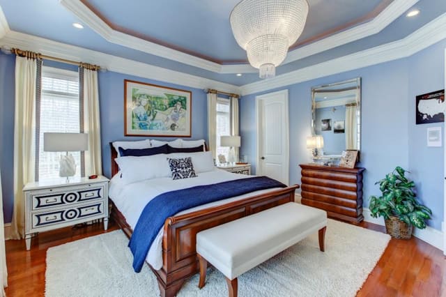 Master Bedroom with ivory shag area rug, custom painted nightstands, custom drapery panels, and two-tier chandelier