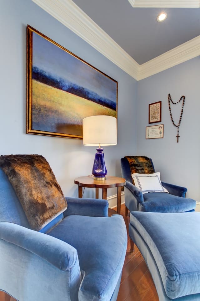 Blue velvet chairs in Master Bedroom with landscape artwork